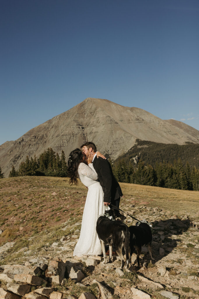 A couple kisses after reading their wedding vows on their elopement day in the Colorado mountains.