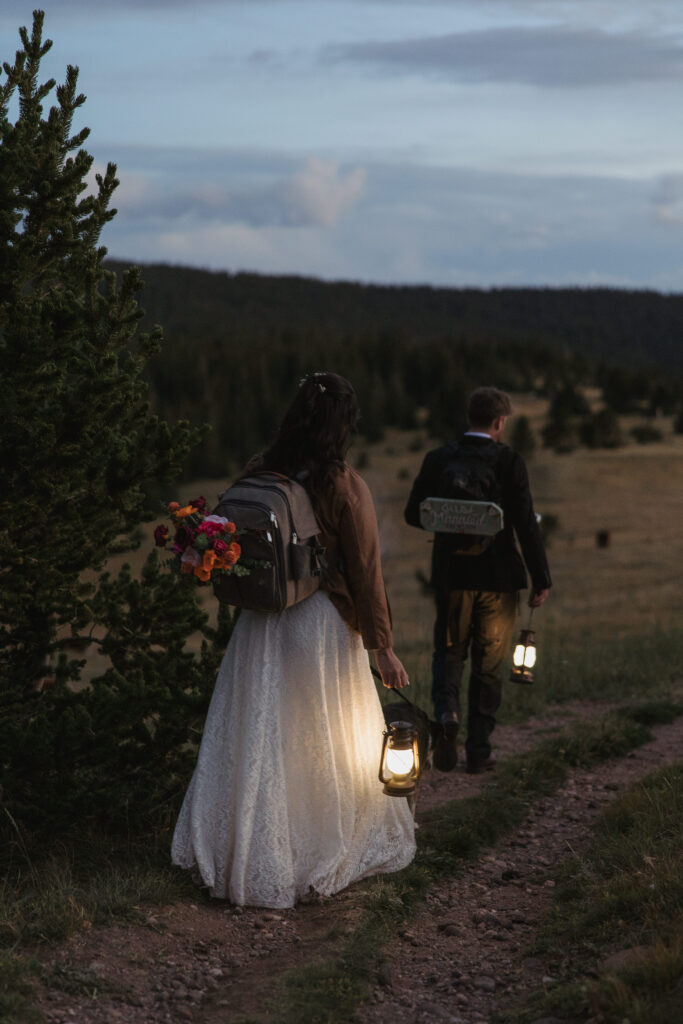 A couple holds lanterns as they hike back to their car in the dark after they eloped at West Spanish Peak.